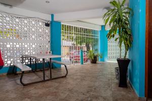 a room with blue walls and a table and a plant at Hotel Las Palmas en Laurel in Cancún