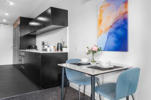 een keuken met een tafel en twee blauwe stoelen bij Cozy & Romantic 1 Bedroom Apt in Southbank with Pool & Gym in Melbourne