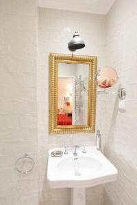 a white bathroom with a sink and a mirror at Villa Estefânia em Sintra in Sintra