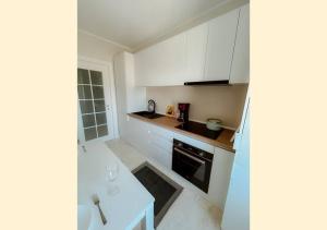 uma pequena cozinha com armários brancos e um lavatório em Royal View Copou 2 rooms AbHomes em Iaşi