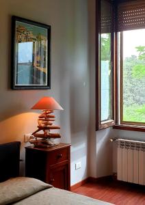 lampa na stole w sypialni z oknami w obiekcie bb26 Piave apartment city center w mieście Cremona
