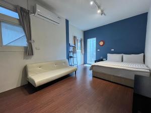 a bedroom with a bed and a couch in a room at Lazy bone in Hsinchu City