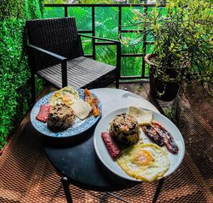 una mesa con dos platos de comida para el desayuno. en Bungalows Las Iguanas Arenal Volcano, en Fortuna