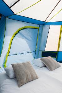 a bed in a tent with two pillows on it at Luxury tent - Villmarkseventyret in Håtvet