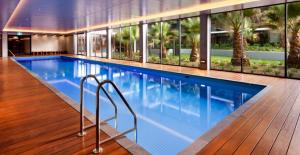 een groot zwembad in een gebouw met ramen bij Cozy & Romantic 1 Bedroom Apt in Southbank with Pool & Gym in Melbourne