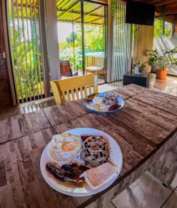 a table with a plate of breakfast food on it at Bungalows Las Iguanas Arenal Volcano in Fortuna