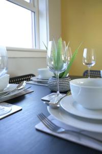 a table with white plates and wine glasses on it at McCracken House in Uddingston