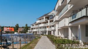 an apartment building with a walkway next to a pool at Apartament Baltic Garden&Sztutowo in Sztutowo