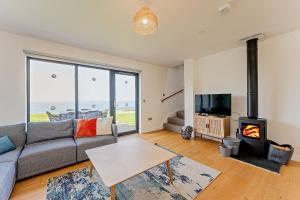 a living room with a couch and a fireplace at 18 - 3 Bedroom Cottage - LP in Pwllheli