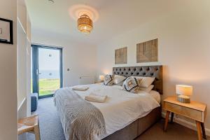 um quarto com uma cama grande e uma janela em 18 - 3 Bedroom Cottage - LP em Pwllheli