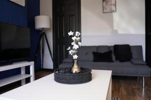 - un salon avec un vase de fleurs sur une table dans l'établissement Sauchie House, 