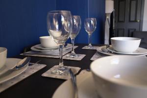 a table with three wine glasses and plates on it at Sauchie House 