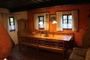 a wooden table in a room with windows at Quiet and charming log farmhouse in Libošovice