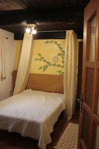een slaapkamer met een bed met gordijnen en een muur bij Quiet and charming log farmhouse in Libošovice