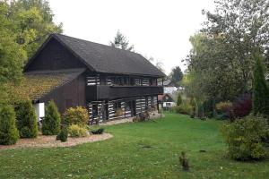 een schuur met een groene tuin ervoor bij Quiet and charming log farmhouse in Libošovice