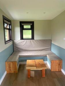 a room with a bed and a table in it at Craigengillan Mini Lodge in Dalmellington