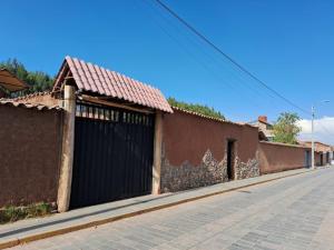 un edificio marrone con un cancello nero su una strada di KOSKO Casa Hotel a Cuzco