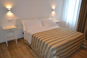 a small bedroom with a bed and two night stands at Hellorooms in Pescara