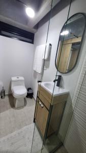 a bathroom with a toilet and a sink and a mirror at Apartment in Bogota, Modelia, Airport in Bogotá