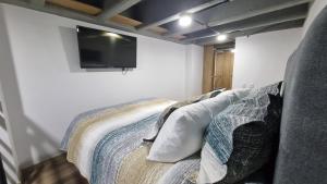 a bedroom with a bed with a tv on the wall at Apartment in Bogota, Modelia, Airport in Bogotá