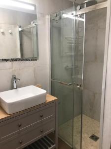 y baño con lavabo y ducha acristalada. en le Clos Lotois - Chambre d'hôtes de charme entre Padirac et Rocamadour, en Gramat