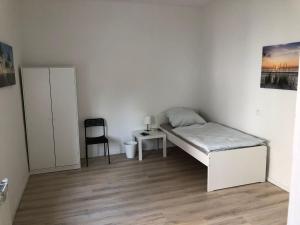 a small bedroom with a bed and a chair at Haus mit 9 Einzelzimmern in Selm-Bork in Selm