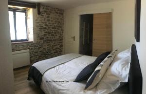 una camera da letto con un grande letto con cuscini sopra di le Clos Lotois - Chambre d'hôtes de charme entre Padirac et Rocamadour a Gramat