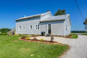 a gray house with a porch in a yard at Cozy Greenwich Vacation Rental with Fire Pit in Greenwich