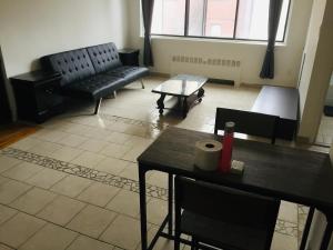 ein Wohnzimmer mit schwarzen Möbeln und einem Tisch in der Unterkunft Stylish Montreal Apartment: Comfortable Stay in the Golden Square Mile in Montreal