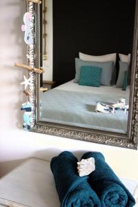 a mirror with towels on a table in front of a bed at Casa Mantana Bonaire in Kralendijk