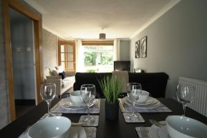 a dining room table with plates and wine glasses at Ravenswood House in Glenrothes