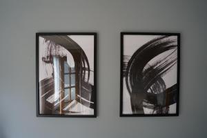 a pair of framed photographs on a white wall at Ravenswood House in Glenrothes