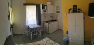 a small kitchen with a table and a table and chairs at Oázis Apartman in Szántód