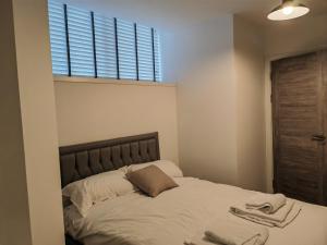 - une chambre avec un lit et des serviettes dans l'établissement Bayard Plaza 1 Bedroom Modern Spacious Apartment, à Peterborough