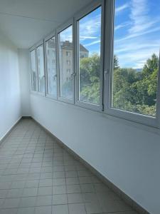 um quarto vazio com 3 janelas e piso em azulejo em U4 Spittelau TR5 em Viena