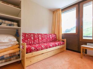 a bedroom with a red couch and a window at Appartement Avoriaz, 2 pièces, 5 personnes - FR-1-314-156 in Morzine
