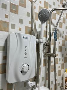 a bathroom with a blow dryer next to a shower at Fivas Residences in Arua