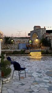 um pátio com 2 cadeiras e uma parede de pedra em Floger world em Vlorë