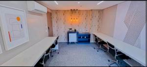 Zimmer mit Schreibtisch und Stühlen in einem Zimmer in der Unterkunft Blend Smart Style - Setor Marista Goiânia in Goiânia
