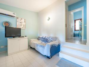 - une chambre avec un lit et une télévision à écran plat dans l'établissement Villino Valentina Best Vacation Ever, à Torre delle Stelle