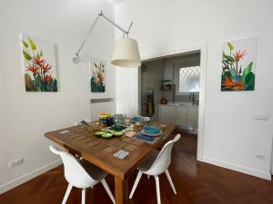a dining room with a wooden table and white chairs at STERLIZIA HOUSE in Rome