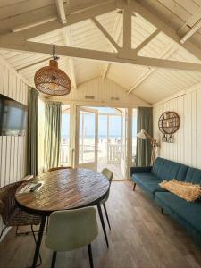 a living room with a table and a blue couch at Willy Zuid in Katwijk aan Zee