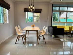 a dining room with a table and chairs at Happy home บ้านกว้าง ได้ทั้งหลัง ไวไฟฟรี1000Mbps ใกล้สนามบินสุวรรณภูมิ in Min Buri