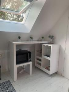 escritorio blanco con microondas y ventana en Studio rénové tout confort, en Donnery