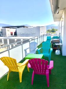 a group of colorful chairs and tables on a balcony at Le Bali- Garage- Terrasse- Relaxant- Belle Vue in Grenoble