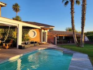 une arrière-cour avec une piscine et une maison dans l'établissement Entre mer et montagne grande villa., à Bompas