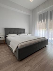 een slaapkamer met een groot bed in een witte kamer bij Bright & Modern 3 Room Apartment with All Amenities and Underground parking in Timişoara