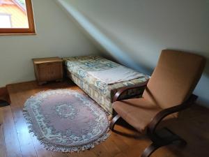 - une chambre avec une chaise à côté d'un petit lit dans l'établissement Domek letniskowy, à Skarszewy