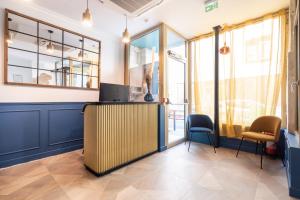 a lobby with a desk and chairs and windows at District Nation in Paris
