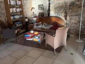 un soggiorno con un divano e un tavolo di Charmantes chambres d'hôtes avec piscine et coin cuisine près de l'abbaye de Solesmes - FR-1-410-404 a Solesmes